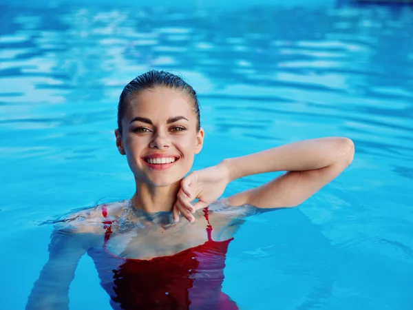 Sonriente bonita mujer en la piscina rojo traje de baño recreación naturaleza —  Fotos de Stock
