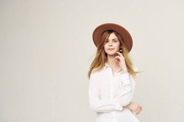 Modern tarz hafif arka plan pozu veren şapka takan çekici bir kadın.