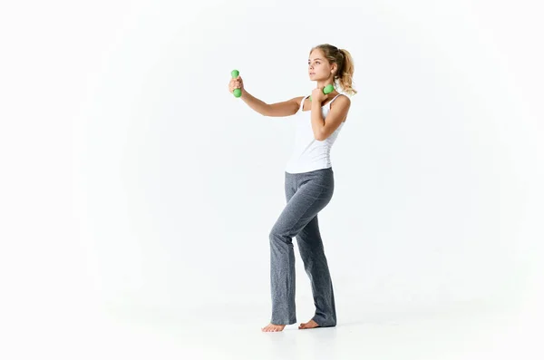 Mujer deportiva sosteniendo pesas verdes en las manos músculos entrenamiento fitness —  Fotos de Stock