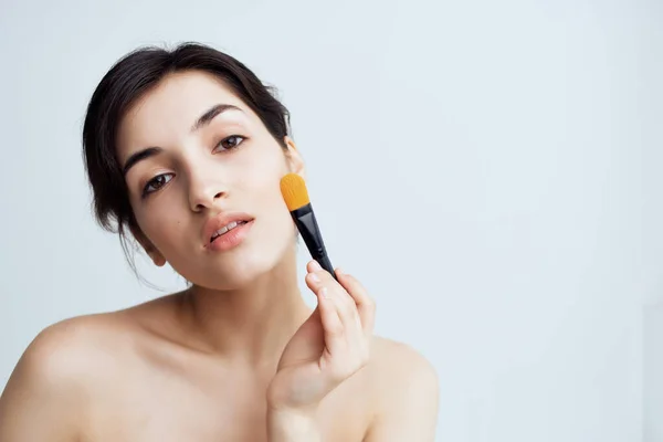 Woman with bare shoulders makeup brush cosmetics skin care close-up — Stock Photo, Image