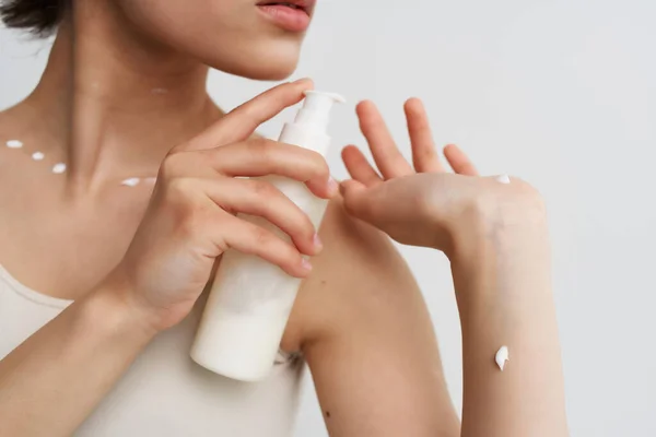 Mulher em t-shirt branca aplica creme para a pele close-up — Fotografia de Stock