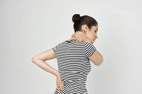 Γυναίκα σε ριγέ t-shirt οσφυαλγία δυσφορία δυσφορία θέα στην πλάτη — Φωτογραφία Αρχείου