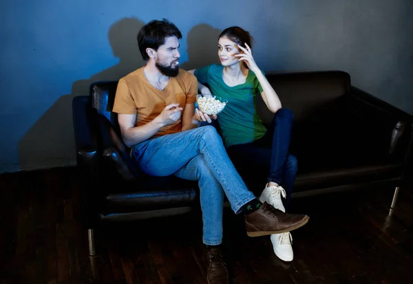 Familia con palomitas de maíz sentado en el sofá viendo la película de televisión — Foto de Stock
