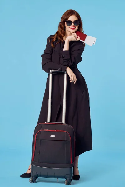 Elegant woman in black coat passenger travel lifestyle blue background — Stock Photo, Image