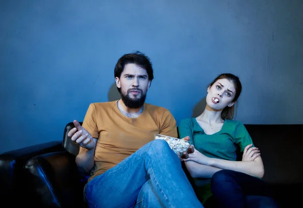 Marido y mujer están sentados en casa por la noche en el sofá viendo la televisión resto — Foto de Stock