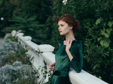 Yeşil elbiseli kadın kırmızı dudaklı romantik park yürüyüşü