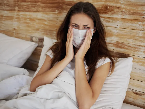 Upset woman in medical mask lies in bed quarantine isolation infection — Stock Photo, Image