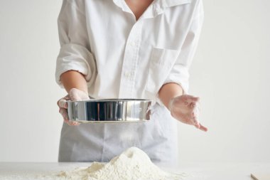 Kadın şef masanda un elliyor fırında pasta pişiriyor.