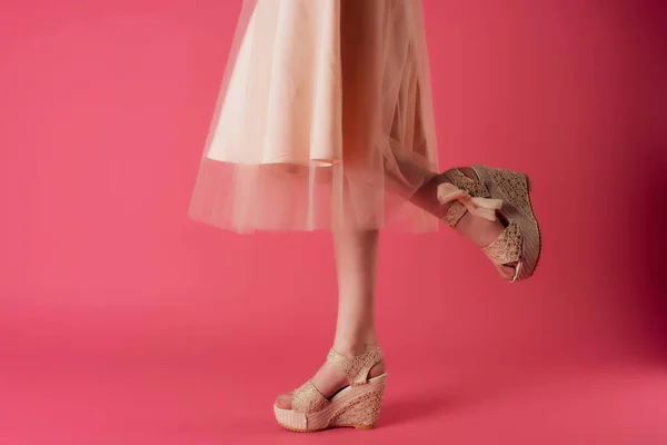 핑크 색 배경을 클로즈업 한 베이지 색 신발을 신고 있는 암컷 다리 — 스톡 사진