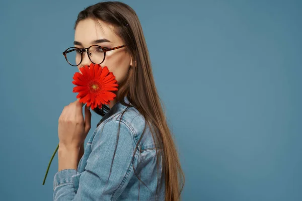 Kvinna bär glasögon röd blomma nära ansikte mode studio — Stockfoto