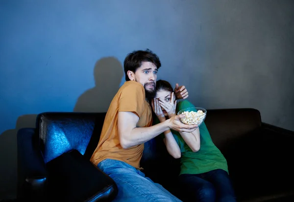 Alegre hombre y mujer sentado en el sofá viendo películas palomitas de maíz vacaciones familiares — Foto de Stock