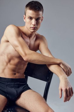 Şişirilmiş çıplak vücutlu bir adam masaya eğilip poz verdi.