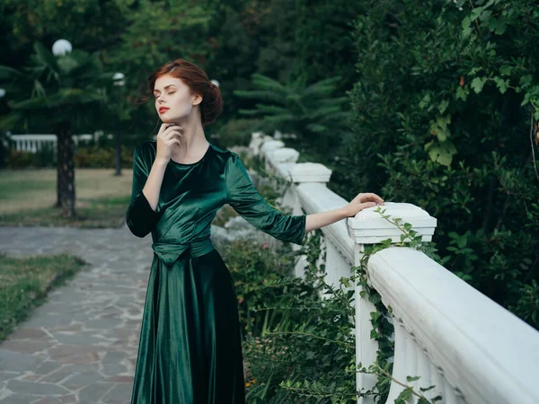 Γυναίκα σε πράσινο φόρεμα στο πάρκο πολυτέλεια ρομαντική βόλτα — Φωτογραφία Αρχείου