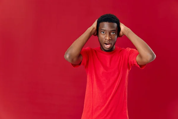 Homem de aparência africana em vermelho t-shirt isolado fundo emoções — Fotografia de Stock
