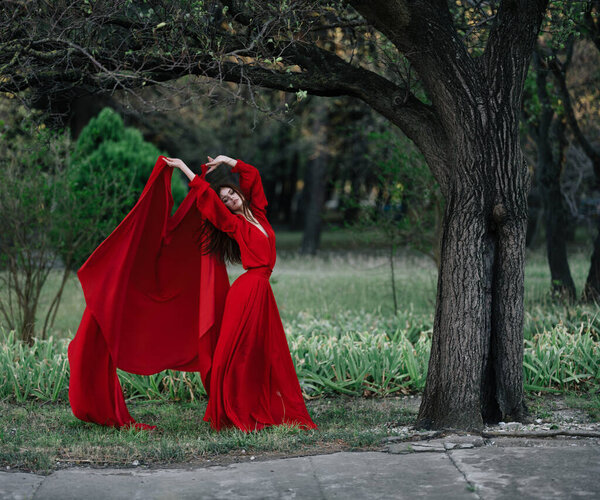 Woman in red dress posing on nature