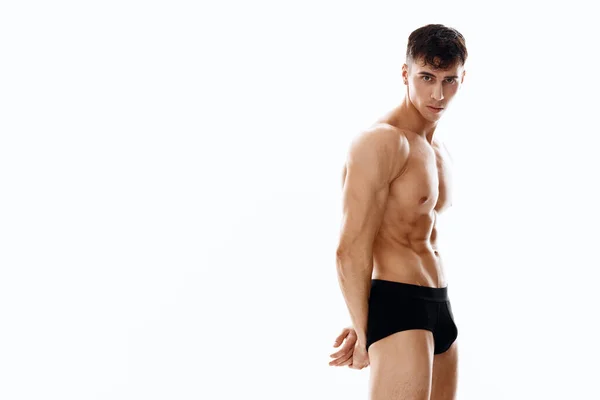 Desnudo atleta masculino posando sobre un fondo claro recortado vista de negro — Foto de Stock