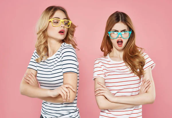 Twee vriendinnen gestreepte t-shirts met zonnebril roze achtergrond — Stockfoto