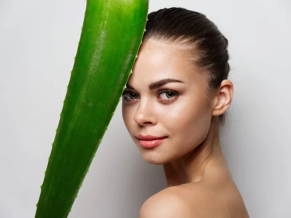 Zielony liść aloesu przed kobieta twarz portret zbliżenie przycięty widok model — Zdjęcie stockowe
