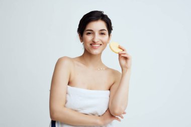 Çıplak omuzlu güzel bir kadın. Temiz cilt süngeri. Ellerinde hijyen.