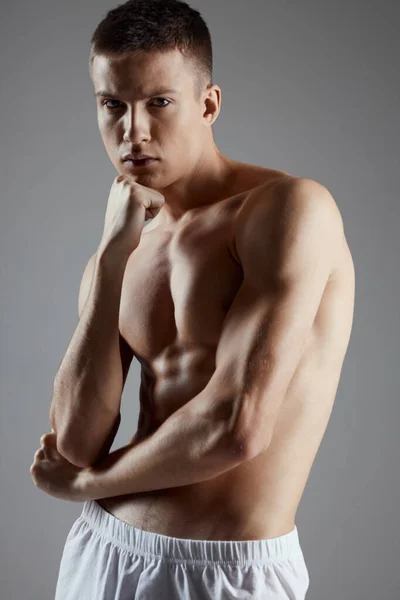 Apuesto deportista con torso desnudo sobre fondo gris y bíceps culturista fitness —  Fotos de Stock