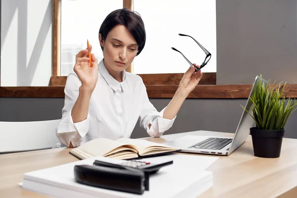 Femme assise à son bureau dans le bureau devant un cadre professionnel de travail d'ordinateur portable — Photo