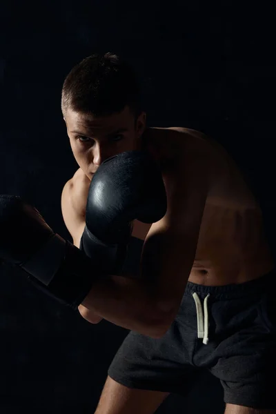 Boxer v rukavicích na černém pozadí ohnutý dolů oříznutý — Stock fotografie
