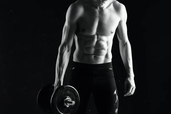 Homme avec haltères dans ses mains nu musclé corps séance d'entraînement fond sombre — Photo