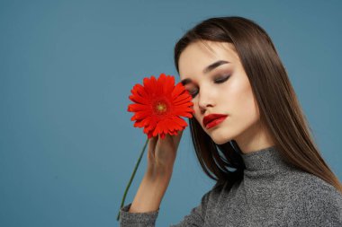Parlak makyajlı güzel bir kadın. Kırmızı çiçek hediyesi. Glamor Stüdyosu.