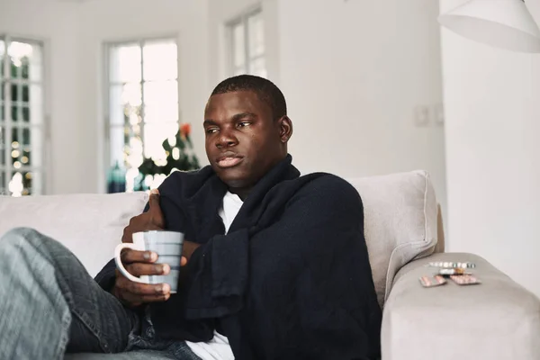 Afrikanisch aussehender Mann sitzt zu Hause auf der Couch Medizin Gesundheitsproblem — Stockfoto