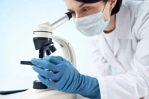 Γυναίκα φορώντας ιατρική μάσκα μικροσκόπιο εργαστήριο τεχνολογίας επαγγελματική — Φωτογραφία Αρχείου