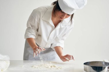 Kadın fırıncı un ile çalışarak para kazanıyor.