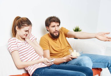 Evdeki kanepede oturan evli çift patlamış mısır duyguları ile film seyrediyor.