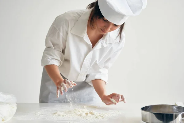Kobieta piekarz rolki ciasta pracy z mąki — Zdjęcie stockowe