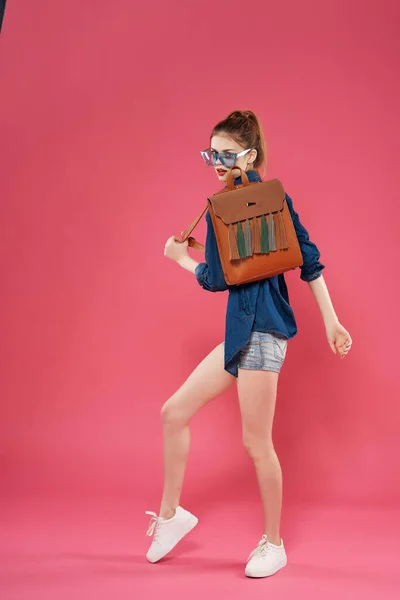 Jovem mulher com mochila posando fundo isolado rosa de comprimento total — Fotografia de Stock