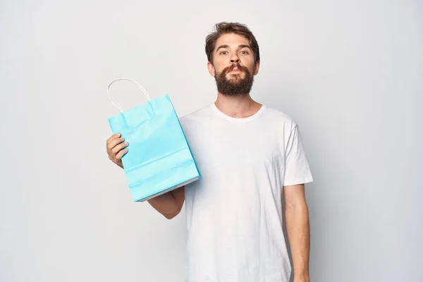 Um homem com um pacote azul em suas mãos comprar roupas de moda loja — Fotografia de Stock