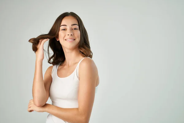 Atraente morena segurando cabelo penteado cuidado estilo de vida isolado fundo — Fotografia de Stock