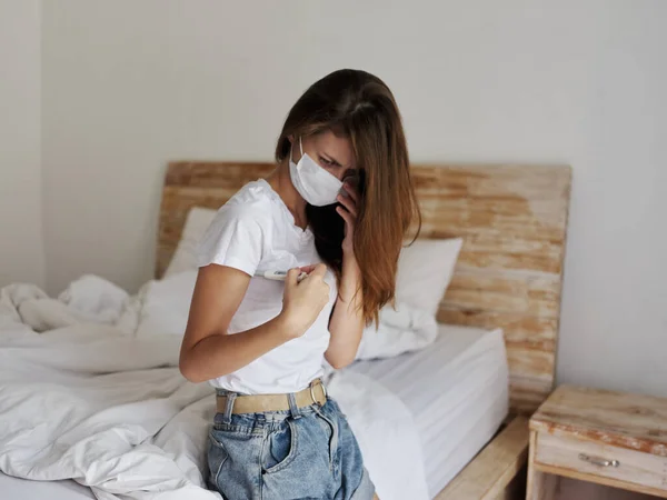 Frau mit medizinischer Maske überprüft Temperatur Gesundheit Schlafraum — Stockfoto