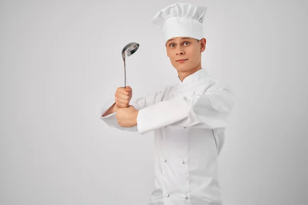 A man in a chefs uniform kitchen utensils work in a restaurant Professional — Stock Photo, Image