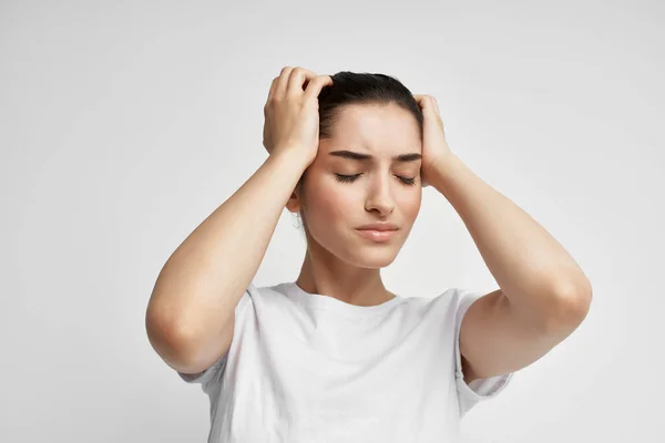 Vrouw in wit t-shirt emotie ongenoegen hoofdpijn gezondheidsproblemen — Stockfoto