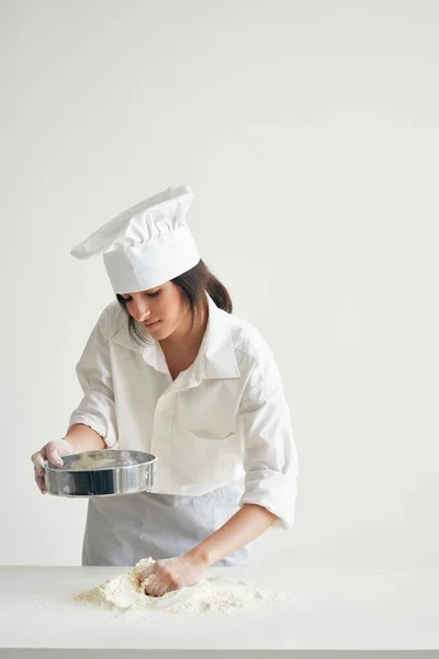woman baker in chefs clothes professional working with dough kitchen