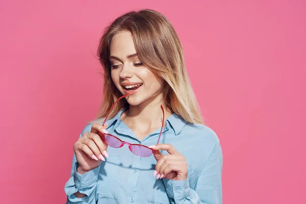Blondine mit Brille blaues Hemd Glamor Spaß rosa Hintergrund — Stockfoto
