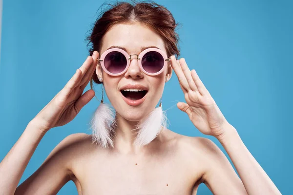 Veselá emocionální žena nosí sluneční brýle módní světlé make-up dekorace modré pozadí — Stock fotografie