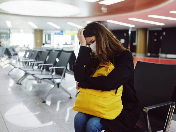 Femme à l'aéroport tenant son masque médical de tête en attente — Photo