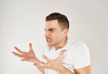 Beyaz tişörtlü, el hareketleriyle hareket eden bir adam.