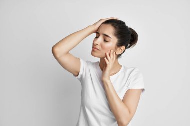 Beyaz tişörtlü bir kadın. Duygu bozukluğu. Baş ağrısı.