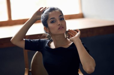 Güzel esmer, pencerenin yanında lüks dekorasyon modeli gibi duruyor.