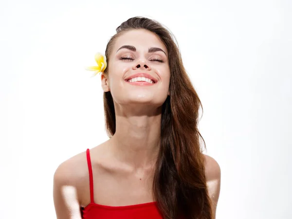 Retrato de una señora feliz en una camiseta roja con una flor amarilla en el pelo —  Fotos de Stock