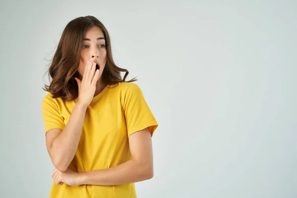 Эмоциональная брюнетка в желтой футболке неожиданное потрясение — стоковое фото