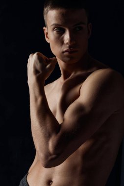 Siyah arka plan vücut geliştirici formda kaslı bir adam.