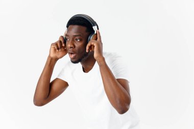 Afrika kökenli bir adam müzik dinlerken kulaklık takıyor.